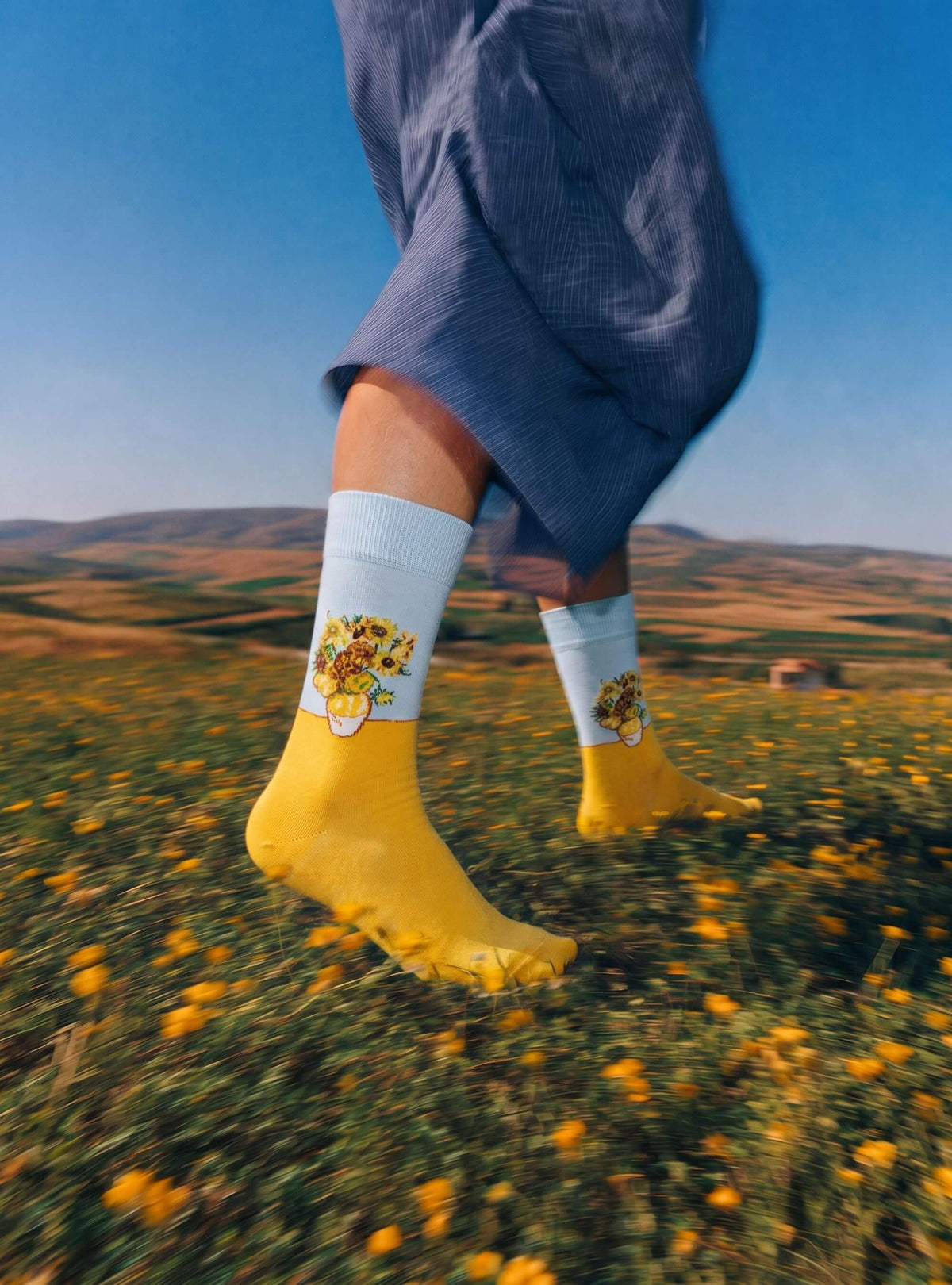 Zonnebloemen kunstsokken van Vincent van Gogh gedragen in een veld met gele bloemen